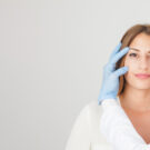 Young woman showing smile, in white casual smart clothing, on grey background, with copyspace area for advertisiment, text or slogan. Advertising concept. Horizontal banner composition.