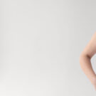 Young woman showing smile, in white casual smart clothing, on grey background, with copyspace area for advertisiment, text or slogan. Advertising concept. Horizontal banner composition.